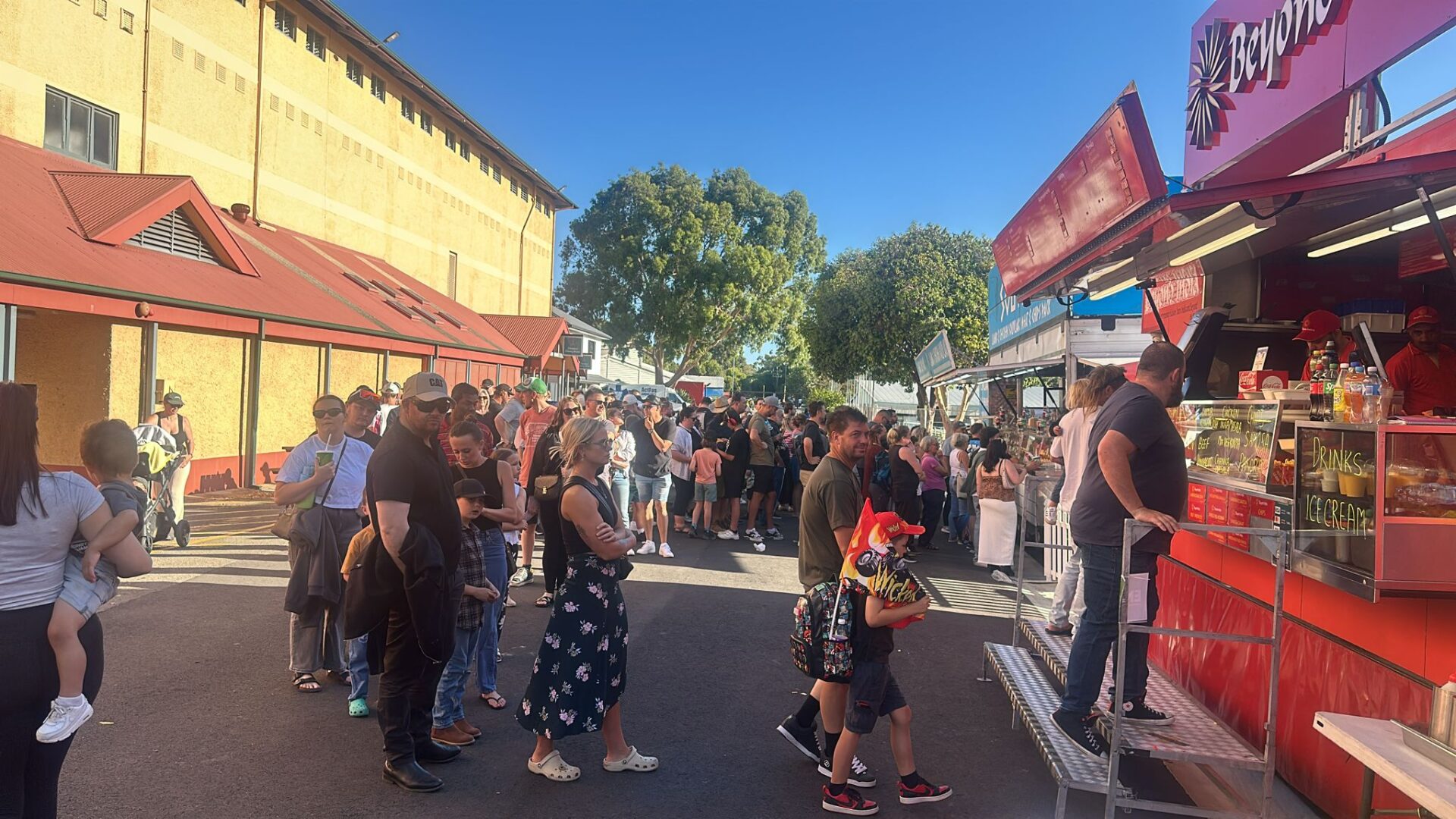 Crowds of people queuing at Beyond India food truck at a busy outdoor Adelaide event on a sunny day